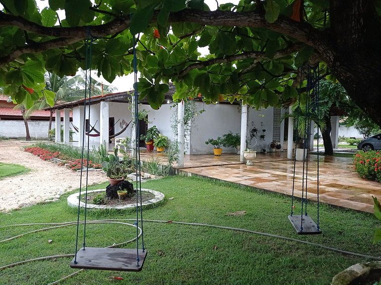 Casa avarandada e espaçosa com amplo jardim florido na Taibi